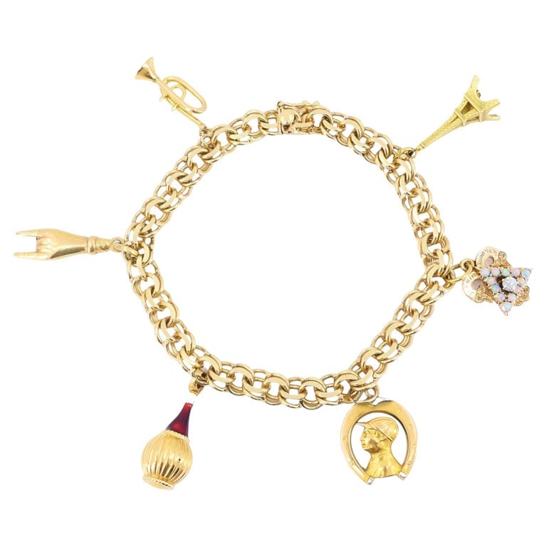 Vintage 14k 18k Gold Charm Bracelet: A vintage charm bracelet crafted in 14k and 18k yellow gold, circa 1950sâ€“1960s. This beautifully assembled bracelet captures the nostalgia of mid-century travel and sentiment throug