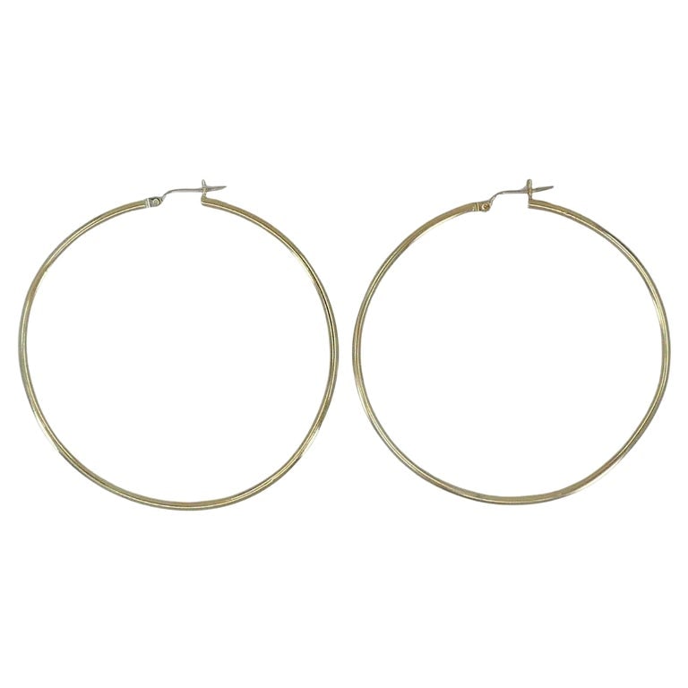 14k Gold Large Hoop Earrings: These large 14k yellow gold hoop earrings feature a timeless round silhouette with a clean, minimalist finish. Measuring 2 1/4 inches in diameter, they offer a bold yet lightweight look thatâS