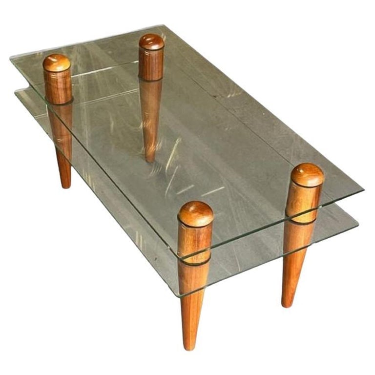 Gilbert Rohde Floating Glass Walnut Coffee Table: Elevate your living space with this 2-Tier floating Glass & Wood Coffee Table inspired by the designs of Gilbert Rohde. Combining 1/2" green glass and rich sculpted walnut wood legs, this stylish tabl