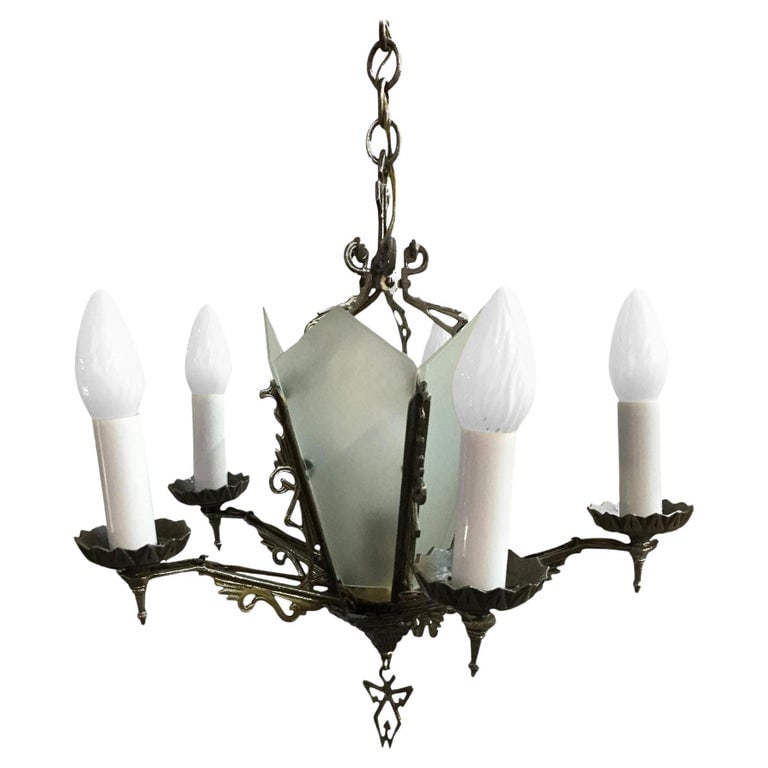Art Deco Slat Glass Chandelier With Geometric Details: Five-arm geometric Art Deco chandelier with candle-style lights and a light-up slat glass center. The piece features scrolling details throughout while the base of the chandelier features a geometric
