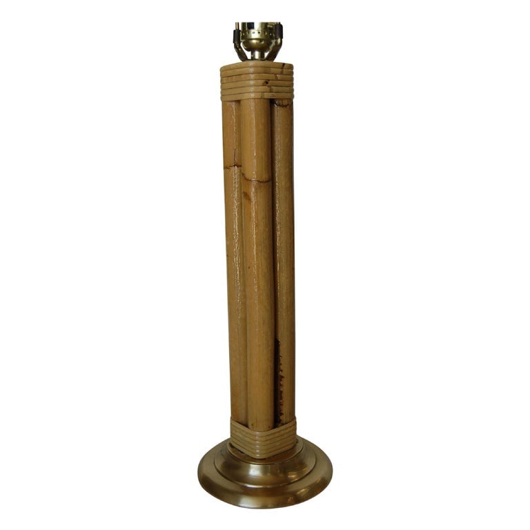Restored Four Strand Rattan Table Lamp with Fancy Wrapping and Brass Base: This beautifully restored Paul Frankl-inspired midcentury round rattan table lamp featuring four decorative rattan poles centered around a rattan post all fixed to a brass circular base with fancy wra