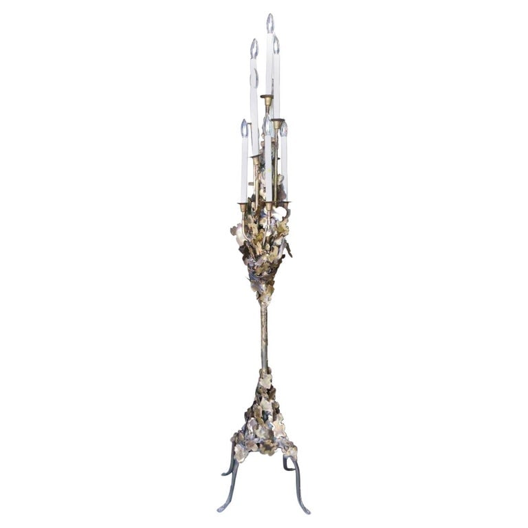 Tom Greene Style Brutalist Torch-Cut Brass Torchiere Floor Lamp: This Tom Greene style Brutalist brass Torchère features a series of multilevel of candles and sculpted torch-cut accents, circa 1970. Reserve: $1,710.00 Shipping: Domestic: Shipping rates are