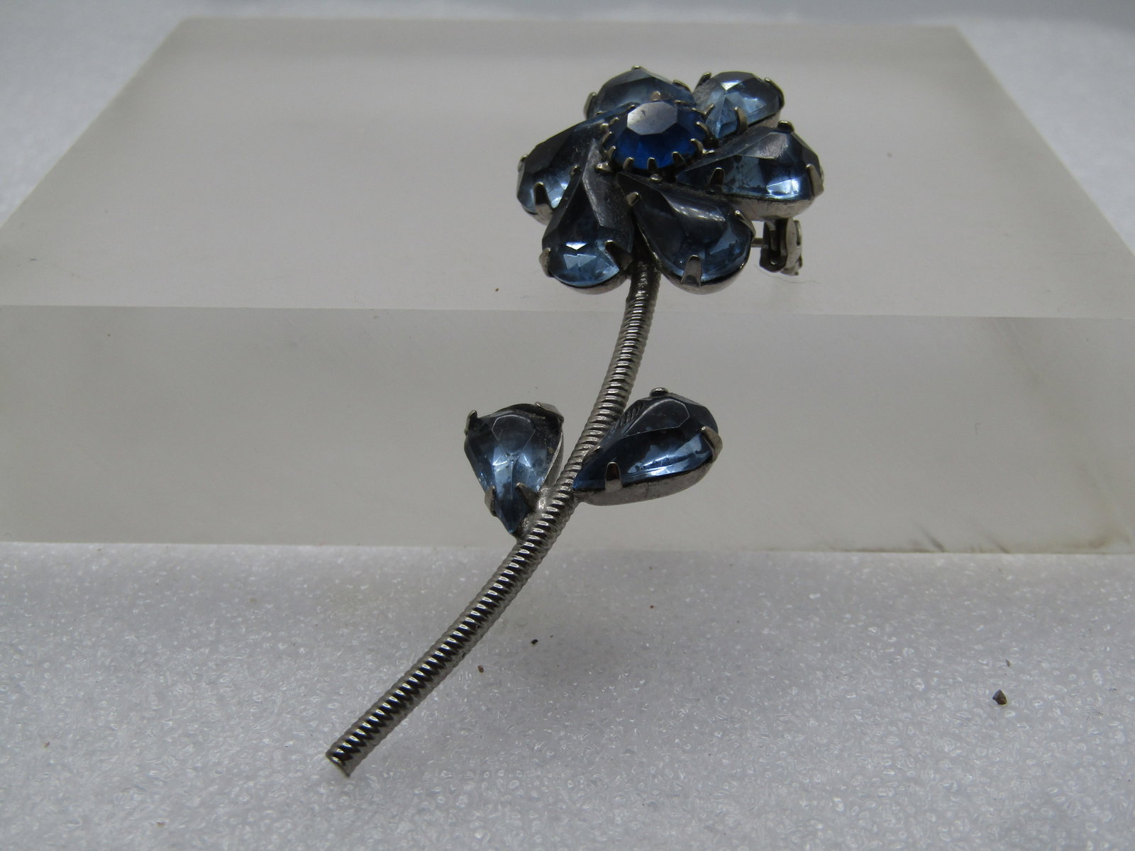 Vintage Blue Rhinestone Floral Stem Brooch, 1960's: Title: Vintage Blue Rhinestone Floral Stem Brooch, 1960's Description: Vintage Blue Rhinestone Floral Stem Brooch, 1960's. It is silver tone and 2.75" tall and 1" wide at the blossom Locking clasp. Th