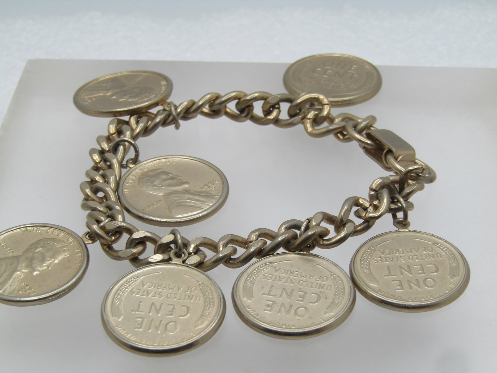 Vintage 1958' Penny Bracelet, Wheat Back, 7": Title: Vintage 1958' Penny Bracelet, Wheat Back, 7" Description: Vintage 1958 D Penny Bracelet, Wheat Back, 7". This has seven pennies set in a bezel dangling from an 1ppx. 6.5mm wide curb link chain 