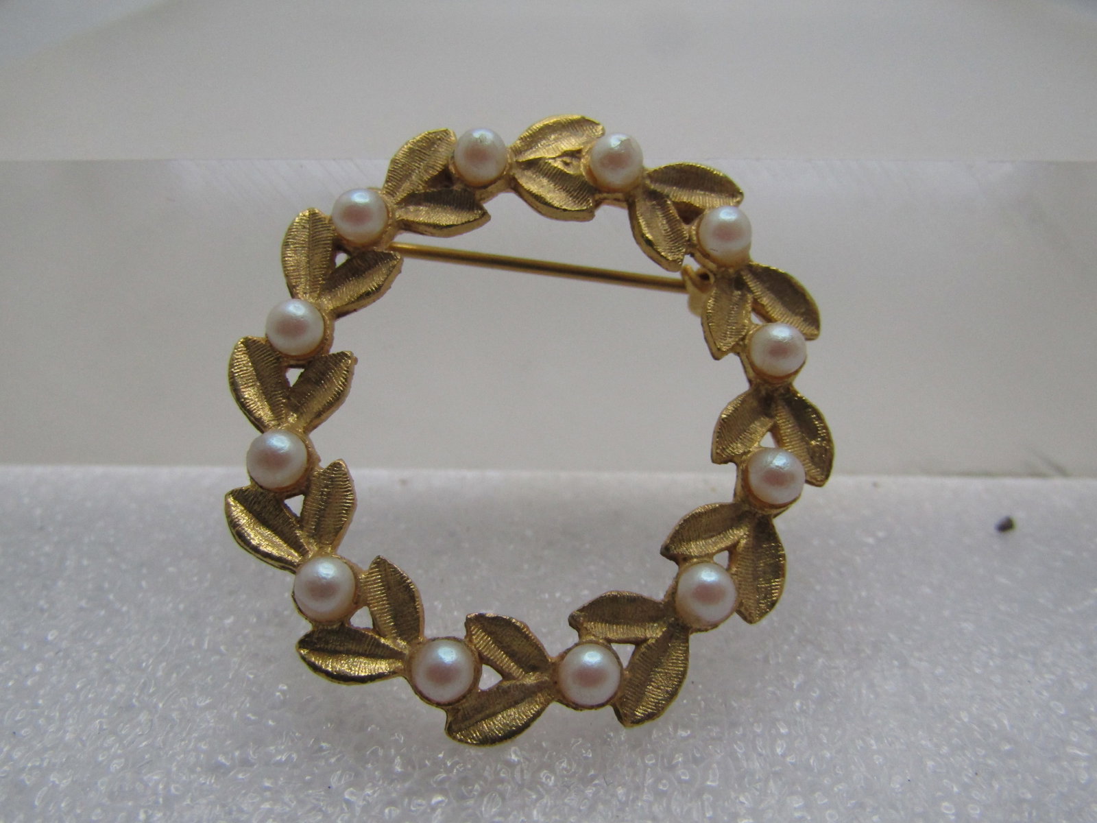 Vintage Faux Pearl Leaf Circle Brooch, 1960's-1970's: Title: Vintage Faux Pearl Leaf Circle Brooch, 1960's-1970's Description: Vintage Faux Pearl Leaf Circle Brooch, 1960's-1970's. The brooch has textured gold tone V shaped leaf design with a single