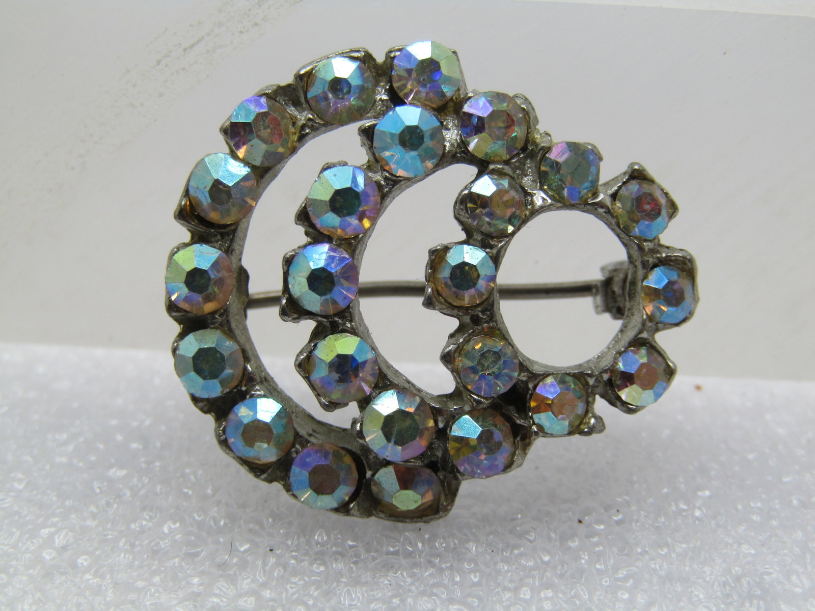 Vintage Aurora Borealis Curved Brooch, 1930's-1940's: Title: Vintage Aurora Borealis Curved Brooch, 1930's-1940's Description: Vintage Aurora Borealis Curved Brooch, 1930's-1940's. Silver tone cast metal with a locking clasp. it has a 5/8" circle of past