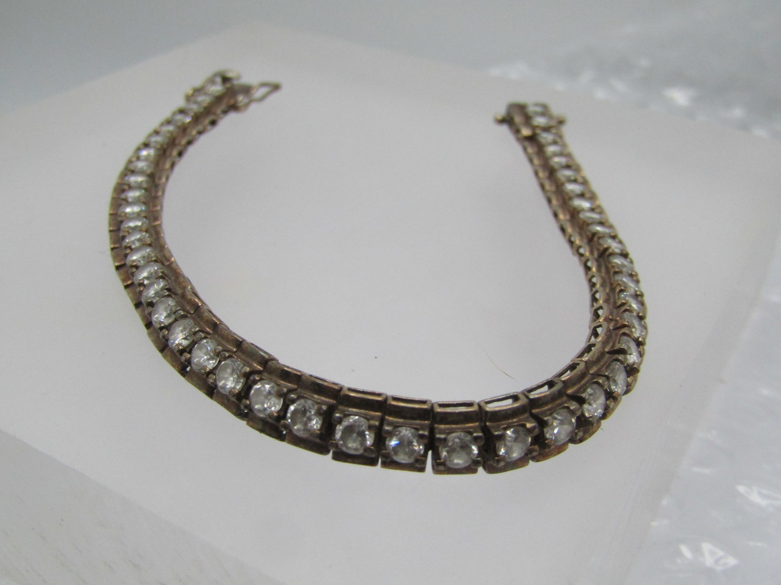 Vintage Sterling CZ Tennis Bracelet, 6mm, 7.25", Signed: Title: Vintage Sterling CZ Tennis Bracelet, 6mm, 7.25", Signed Description: Vintage Sterling CZ Tennis Bracelet, 6mm, 7.25", Signed R. This has a center of 3mm clear rhinestones set over a base wider 