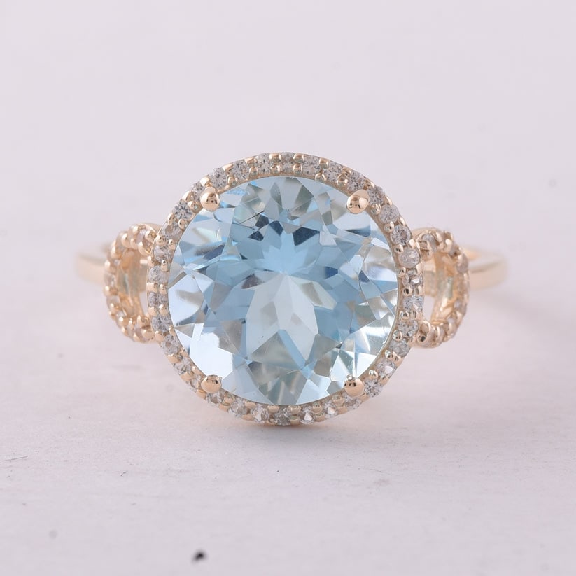4.80 Ct Round Blue Topaz 9K Gold Ring: 4.80 Total Carat Blue Topaz 9K Gold Ring Specifications: Total Weight 2.769 g Center Gemstone Blue Topaz Gemstone Carat Weight 4.58 Carats Gemstone Measurements 10 mm Additional Gemstones White Sapphi
