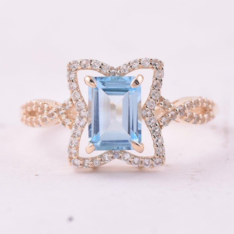 1.67 Ct Octagon Blue Topaz 9K Gold Ring: 1.67 Total Carat Blue Topaz 9K Gold Ring Specifications: Total Weight 2.06 g Center Gemstone Blue Topaz Gemstone Carat Weight 1.38 Carats Gemstone Measurements 7X5 mm Additional Gemstones White Sapphi