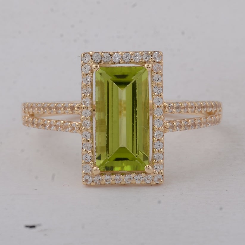 1.81 Ct Baguette Peridot 9K Gold Ring: 1.81 Total Carat Peridot 9K Gold Ring Specifications: Total Weight 2.14 g Center Gemstone Peridot Gemstone Carat Weight 1.49 Carats Gemstone Measurements 10X5 mm Additional Gemstones White Sapphire