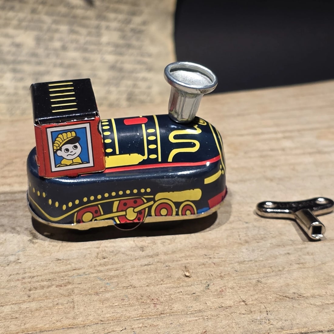 Tin Litho Locomotive Toy Wind Up Train Engine: Reproduction Vintage-style tin lithograph locomotive toy featuring colorful railroad graphics and a side-mounted wind-up mechanism. Tin train toys were among the most popular mechanical toys of the ea