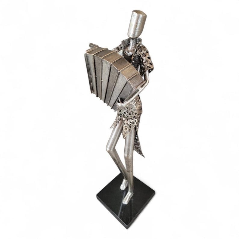 Vintage Metal Art Organ Player Statue: Vintage Metal Art Organ Player Statue on Black Base Charming vintage metal art sculpture depicting an organ player in a lively, expressive pose. Mounted on a sleek black base, the piece combines whims