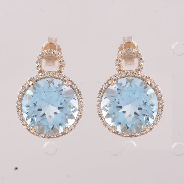 9.77 Ct Round Blue Topaz 9K Gold Earrings: 9.77 Total Carat Blue Topaz 9K Gold Earrings Specifications: Total Weight 3.875 g Center Gemstone Blue Topaz Gemstone Carat Weight 9.41 Carats Gemstone Measurements 10 mm Additional Gemstones White Sa