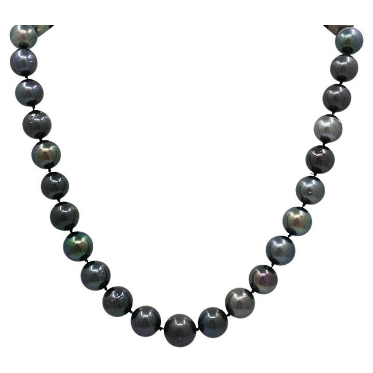 Tahitian Pearl Strand Necklace 14k Gold Clasp: Title: Tahitian Pearl Strand Necklace 14k Gold Clasp Description: Elegant strand of genuine Tahitian black pearls, expertly knotted and finished with a 14k white gold ribbed ball clasp. The graduated 