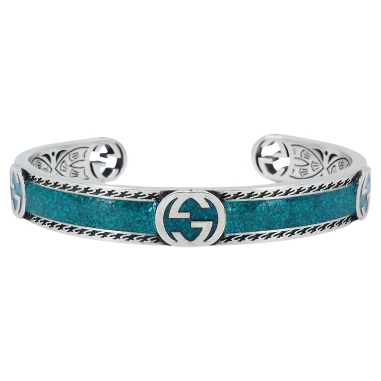 Gucci Sterling Silver Enamel Interlocking G Cuff Bracelet: Title: Gucci Sterling Silver Enamel Interlocking G Cuff Bracelet Description: This Gucci sterling silver enamel cuff bracelet highlights the brandâ€™s signature craftsmanship and