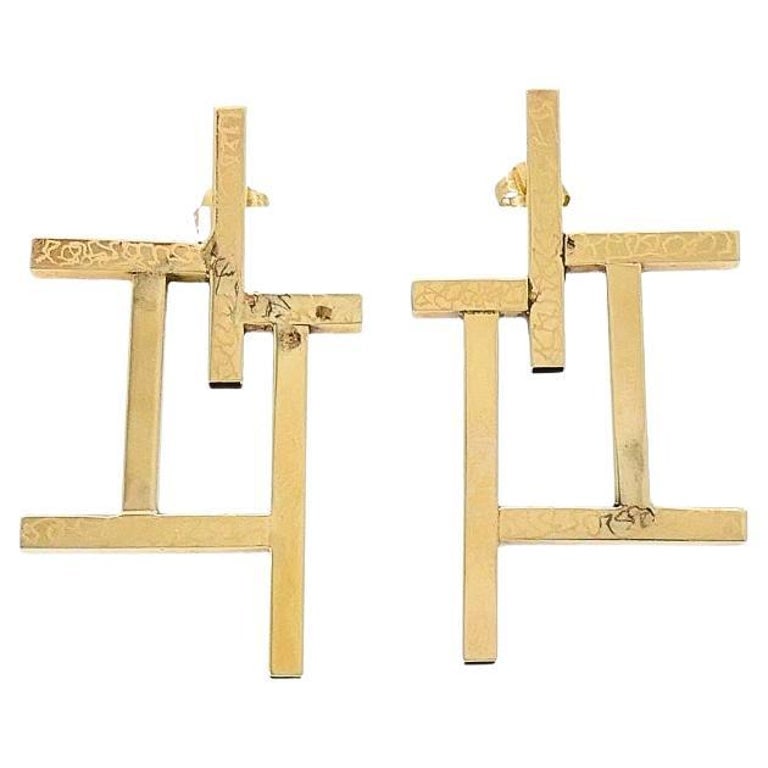 14k Gold Geometric Earrings Frame Design: Title: 14k Gold Geometric Earrings Frame Design Description: These 14k gold earrings feature an unusual geometric design. Intersecting lines and squares create a bold, structured look. The open-frame