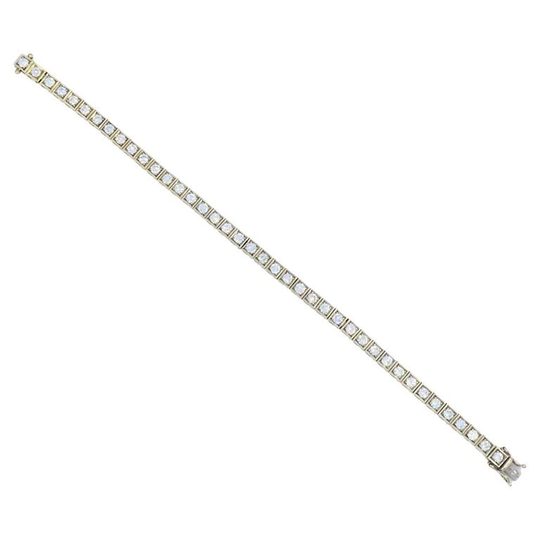 Tennis Bracelet Art Deco 18k Gold Diamond: Title: Tennis Bracelet Art Deco 18k Gold Diamond Description: This 18k gold tennis bracelet features a clean, structured line of 40 square-cut diamonds, channel set in a continuous row. The diamonds h