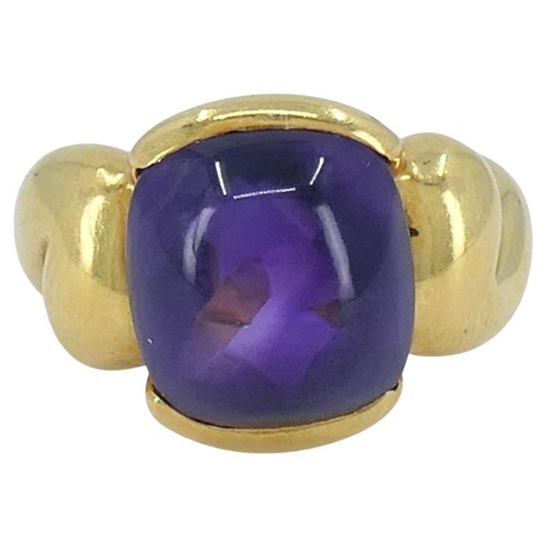 Gucci 18k Gold Amethyst Ring 6.5: Title: Gucci 18k Gold Amethyst Ring 6.5 Description: This Gucci ring is crafted in 18k yellow gold and features a bold cabochon-cut amethyst at its center. The gemstone is bezel-set and framed by