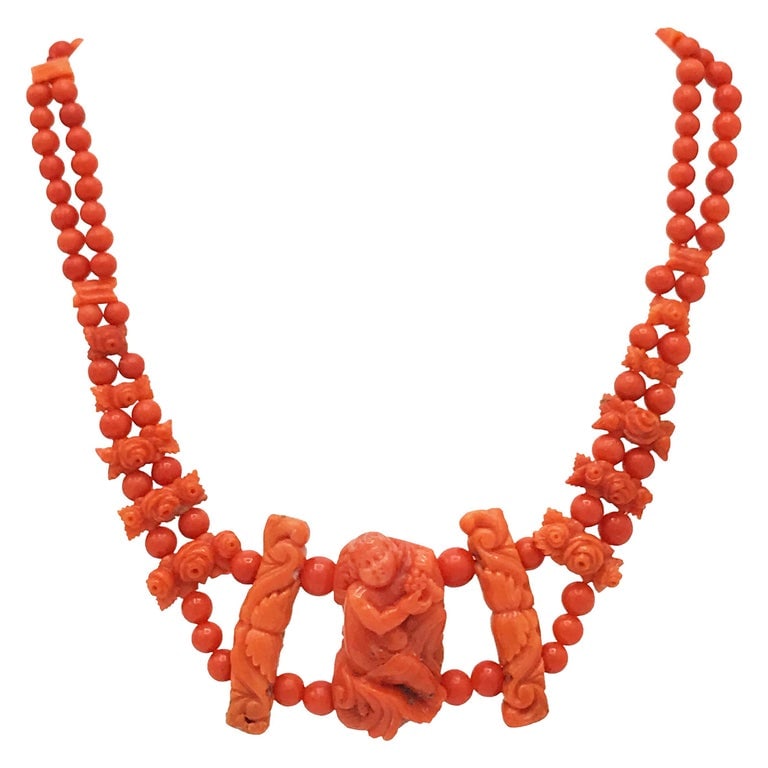 Antique Carved Coral Necklace: Title: Antique Carved Coral Necklace Description: Unique carved coral necklace (circa 1900). The central part is a carved figure of a boy holding a grape. On the sides there are floral elements and th