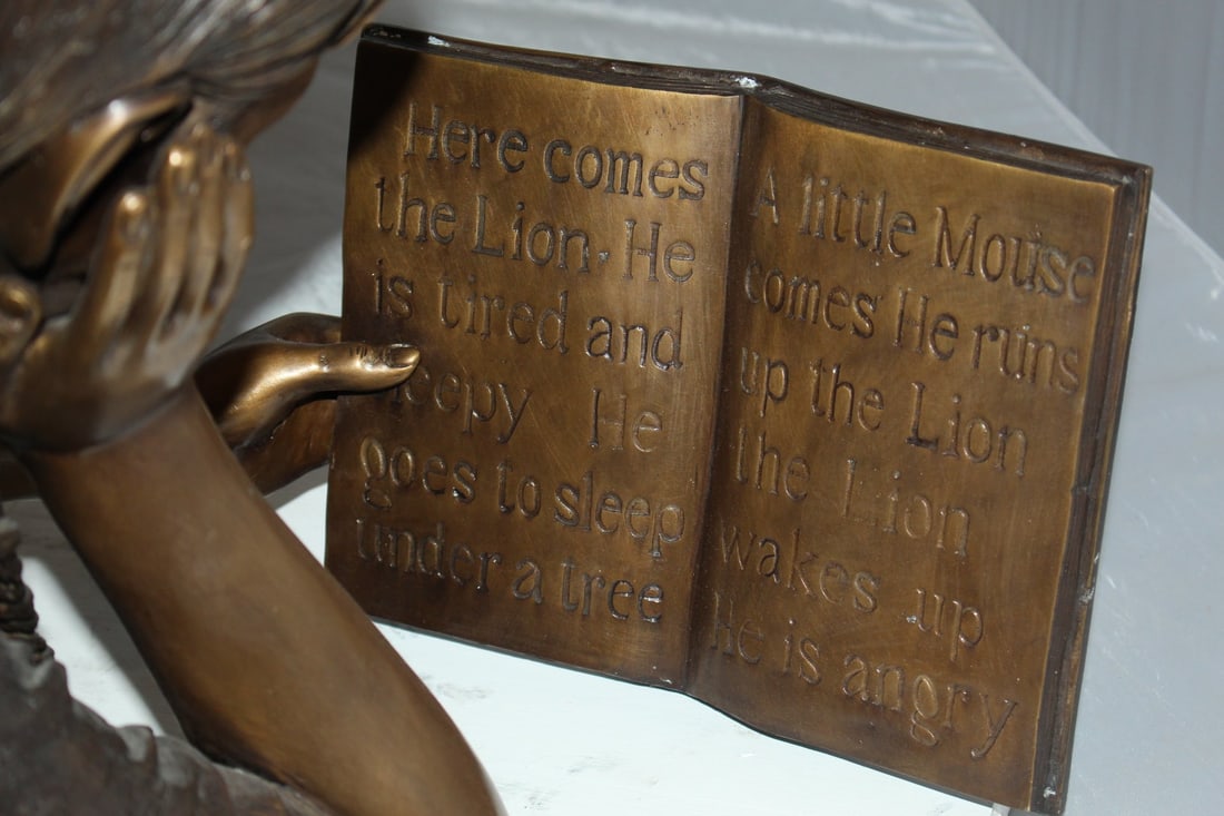 Girl laying reading a book Bronze Statue - Size: 36"L x 17"W x 18"H. - 10