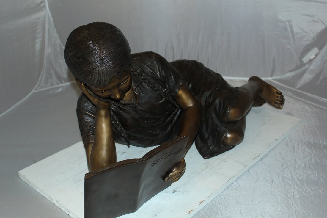 Girl laying reading a book Bronze Statue - Size: 36"L x 17"W x 18"H. - 12