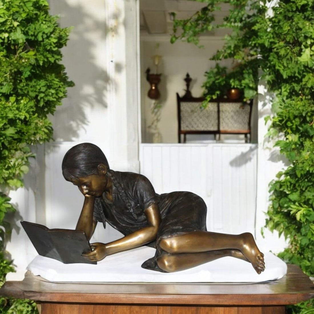 Girl laying reading a book Bronze Statue - Size: 36"L x 17"W x 18"H. - 2