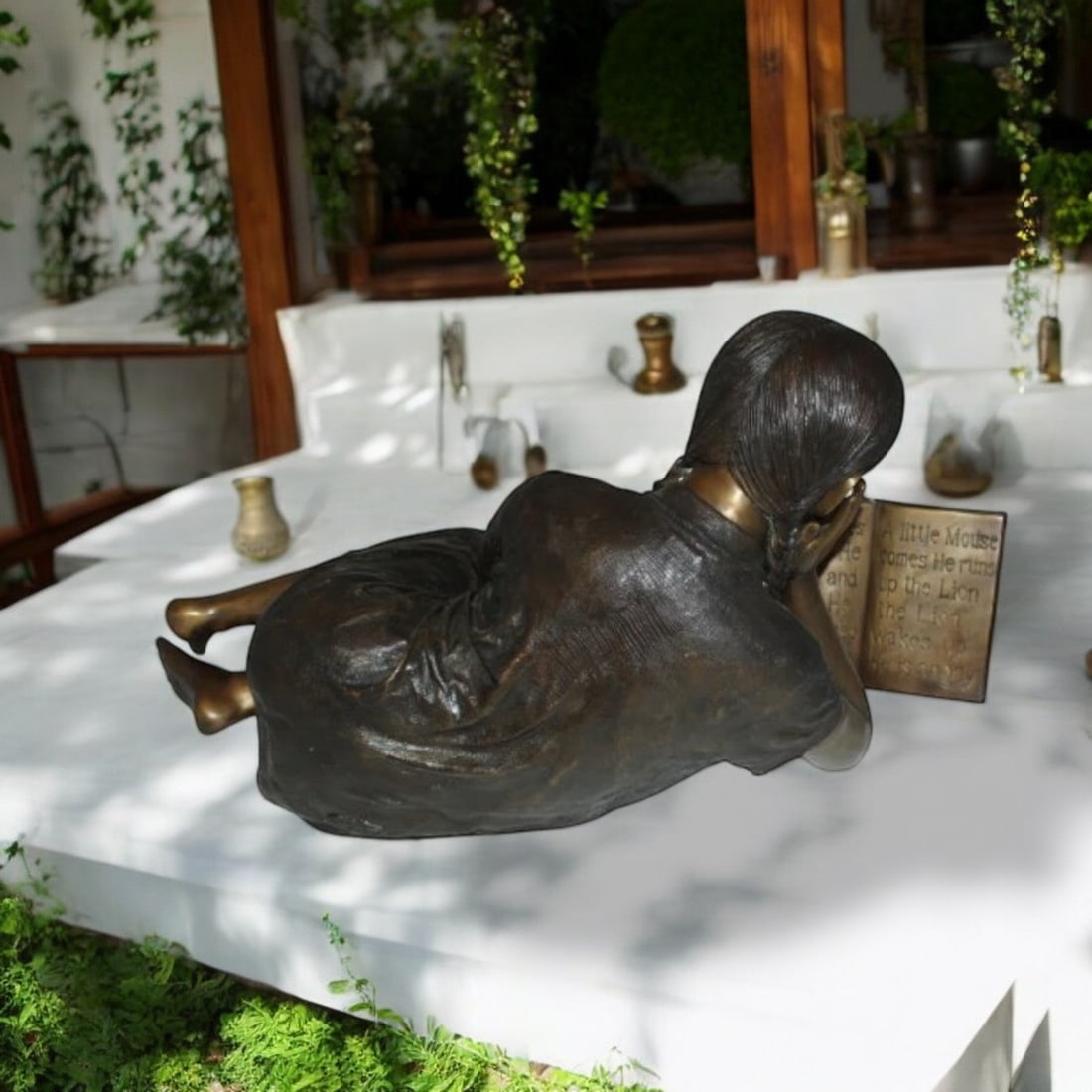 Girl laying reading a book Bronze Statue - Size: 36"L x 17"W x 18"H. - 3