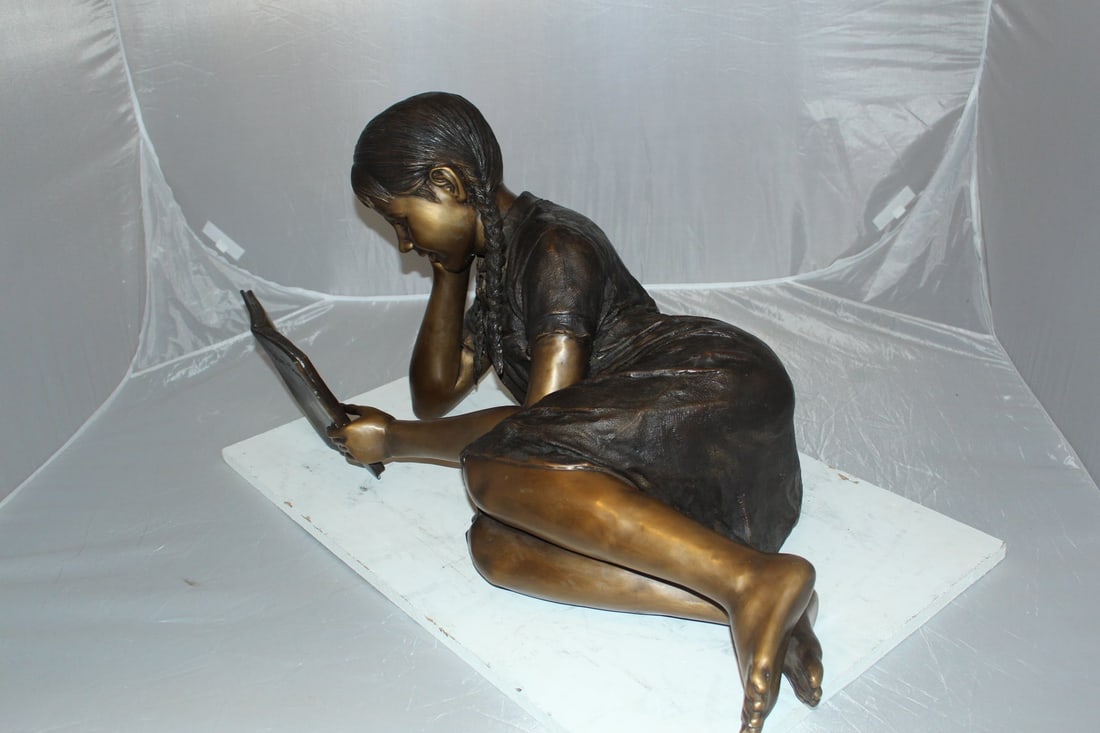 Girl laying reading a book Bronze Statue - Size: 36"L x 17"W x 18"H. - 6
