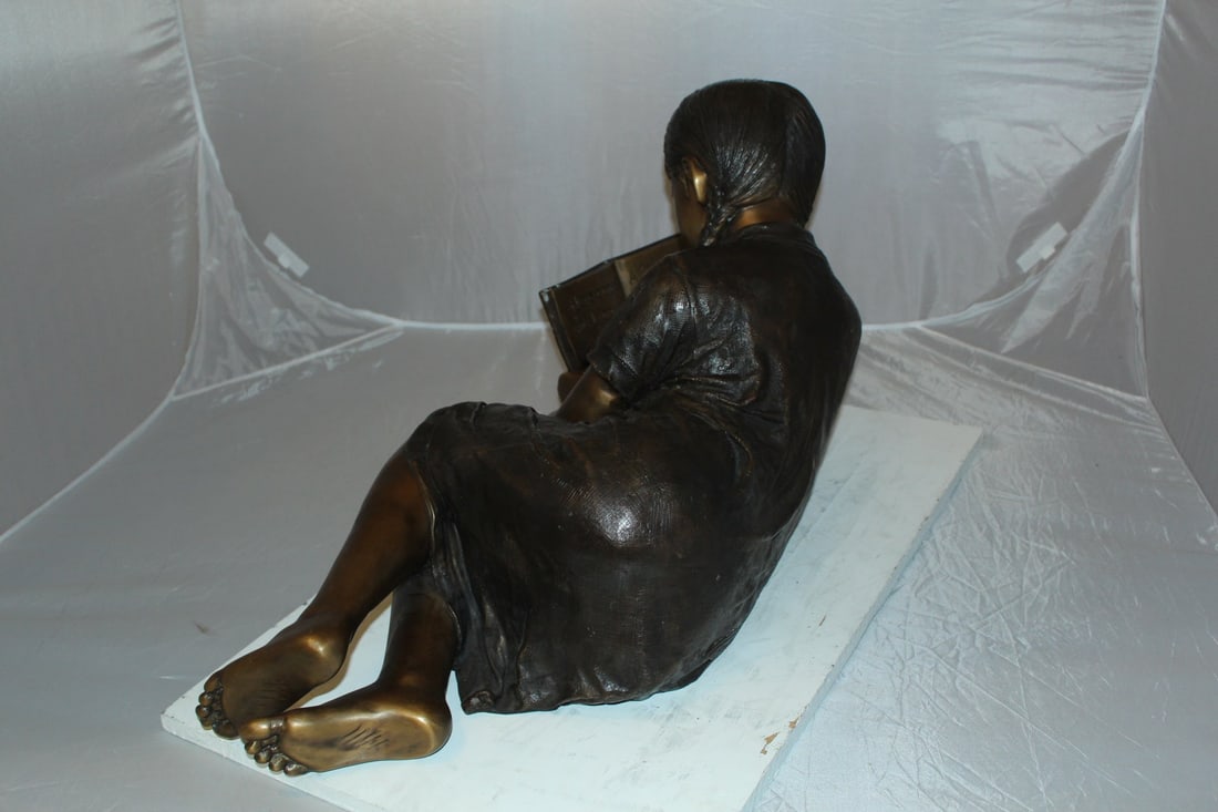 Girl laying reading a book Bronze Statue - Size: 36"L x 17"W x 18"H. - 8