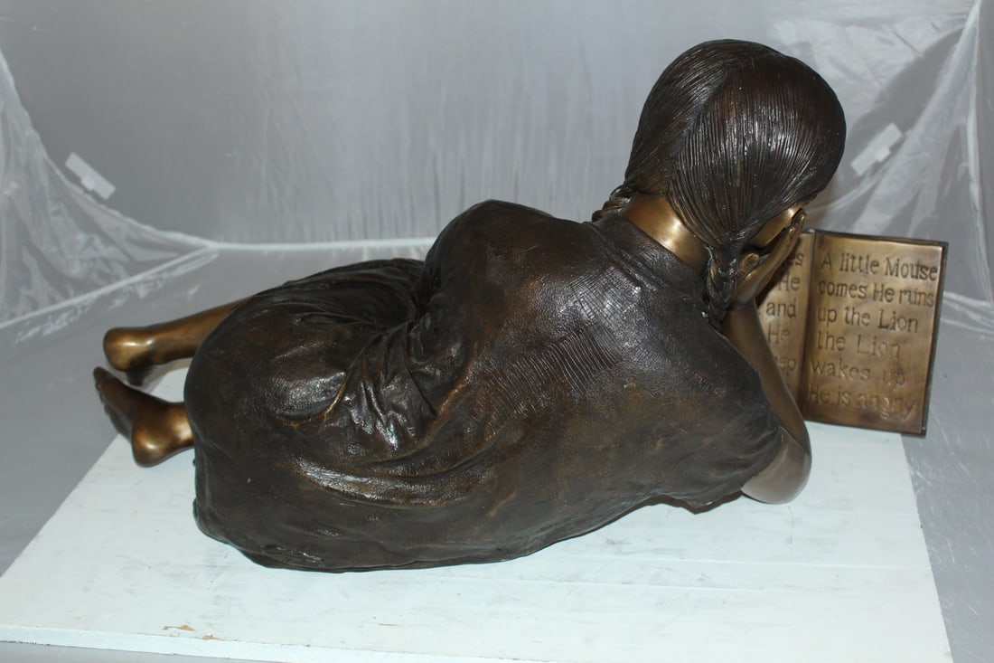 Girl laying reading a book Bronze Statue - Size: 36"L x 17"W x 18"H. - 9