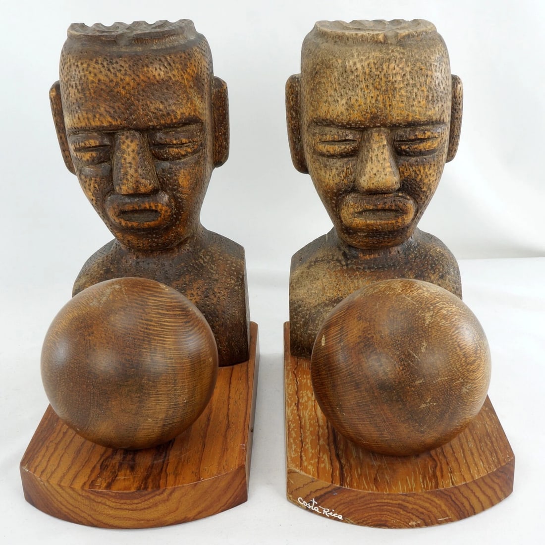 Pair Mesoamerican-Inspired Wood Bookends: Title:Pair Mesoamerican-Inspired Wood Bookends Size:7 in (17.8 cm) long x 4 in (10.2 cm) wide x 8 in (20.3 cm) tall. Description:A pair of wooden bookends with an ethnographic design that portray figu