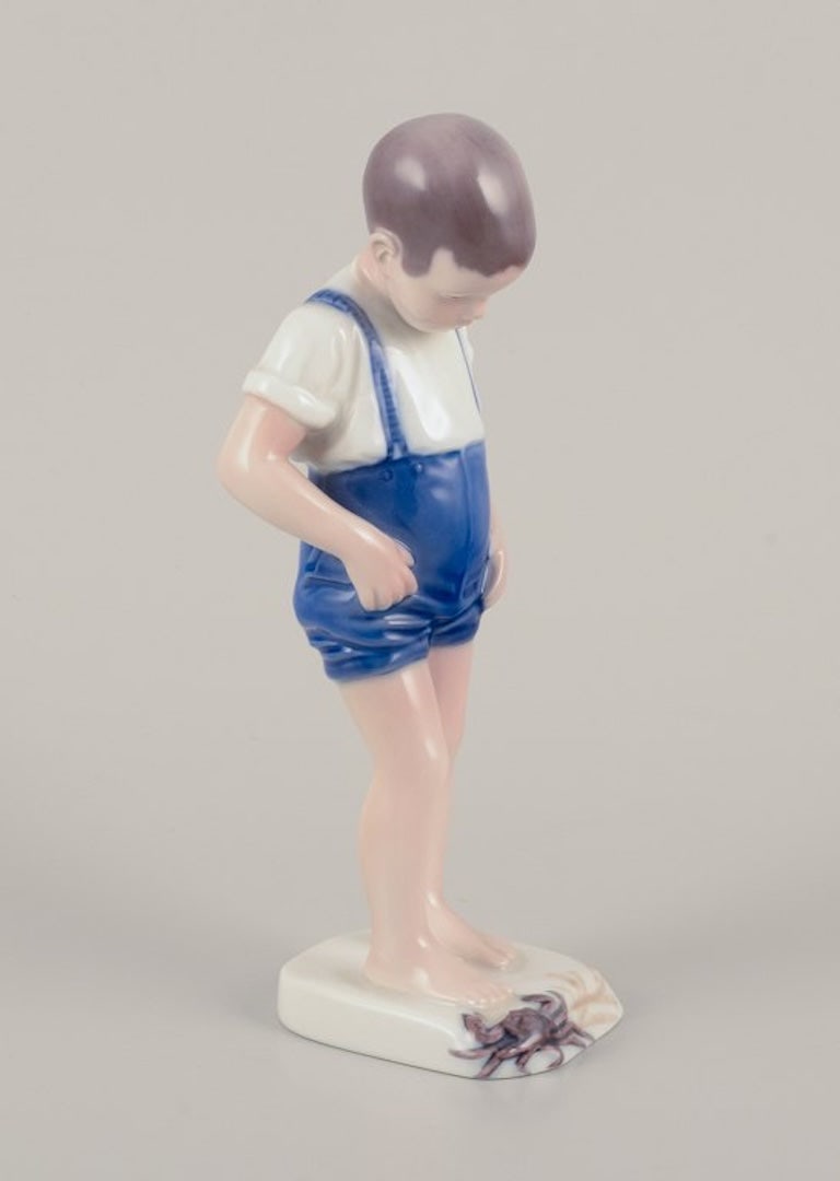 Bing & Grøndahll, Denmark. Porcelain figurine of a boy and crab. Mid-20th century. - 2
