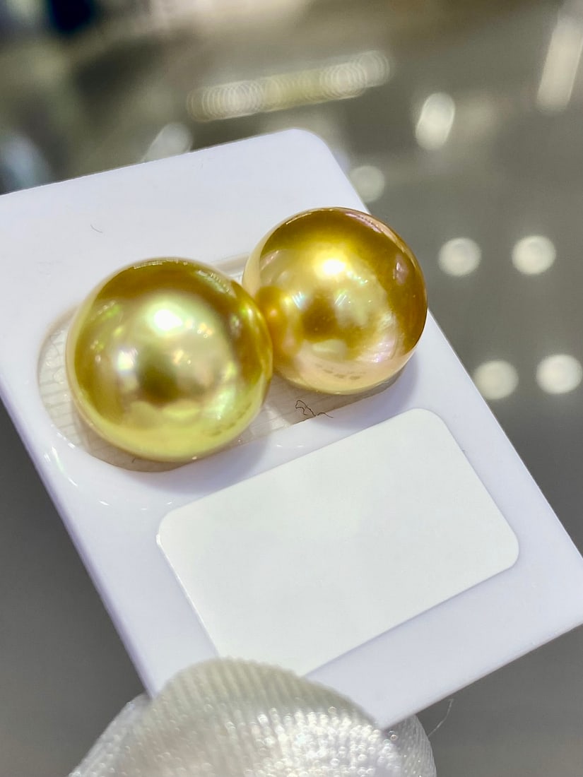 Natural South Sea Golden Pearl Earrings: Title: Natural South Sea Golden Pearl Earrings Description: These earrings feature natural South Sea golden pearls, exhibiting an enchanting golden-green hue with an oil-like luster. The pearls have