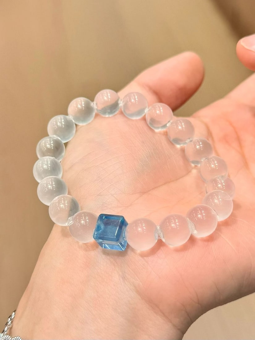 White Crystal Bracelet: Title: White Crystal Bracelet Description: This bracelet features double A grade white crystal beads, each approximately 11mm in diameter, exuding a pure and translucent luster. Paired with an aquamar