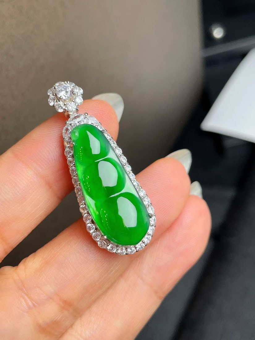 Silver Full Green Jadeite Bean: Title: Silver Full Green Jadeite Bean Description: This jadeite bean is renowned for its full green color and lustrous texture, exuding an elegant aura. Its perfect bright green hue adds endless
