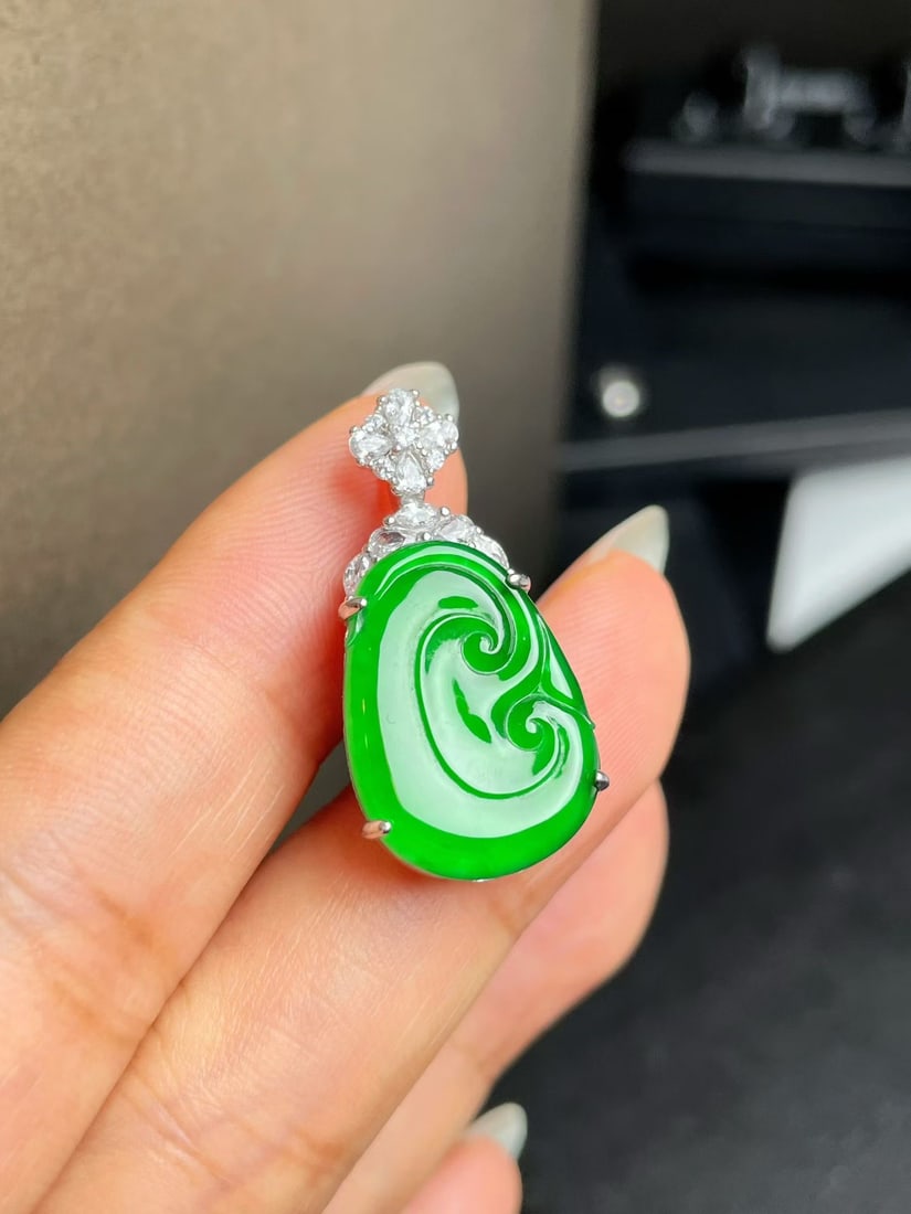 Silver Jadeite Ruyi Pendant: Title: Silver Jadeite Ruyi Pendant Description: This jadeite Ruyi pendant showcases the natural allure of jadeite, with vibrant color and sufficient translucency, offering a simple yet sophisticated