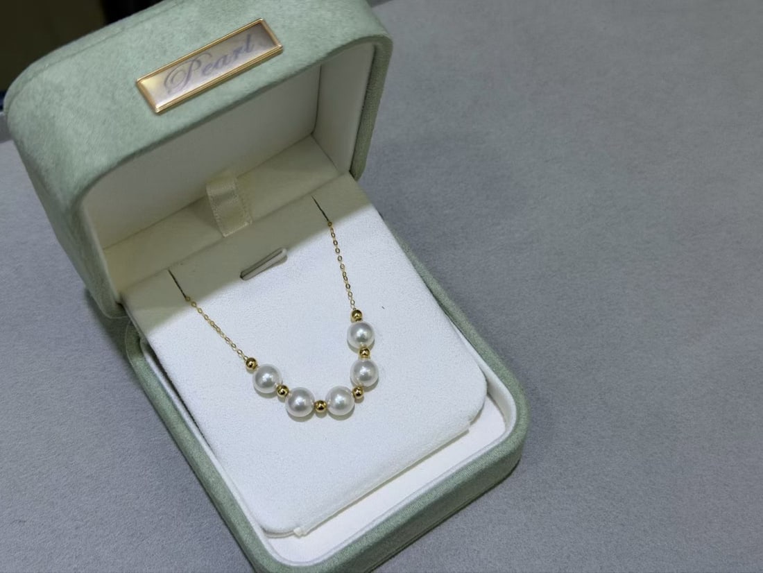 18K Gold Pearl Necklace: Title: 18K Gold Pearl Necklace Description: This necklace features an 18K gold chain paired with 6-7mm perfectly round aurora freshwater pearls, exuding elegance and nobility. Two different wearing