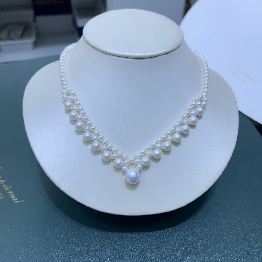 Pearl Necklace: Title: Pearl Necklace Description: This pearl necklace features a handcrafted teardrop design, showcasing the natural beauty of pearls. The pearls range from 4-11mm, nearly round with slight