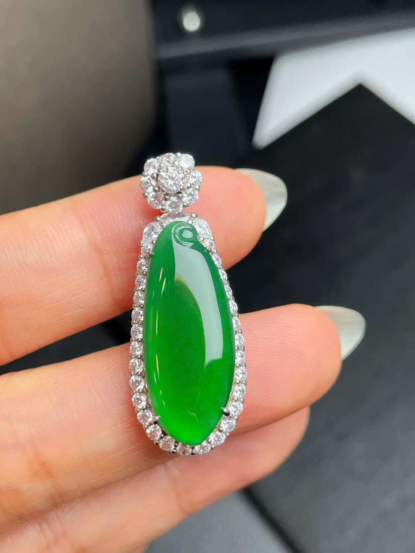 Silver Full Green Jadeite Pendant: Title: Silver Full Green Jadeite Pendant Description: This jadeite pendant features a full green hue, with a lustrous and watery appearance, symbolizing abundant fortune. Its excellent quality makes i