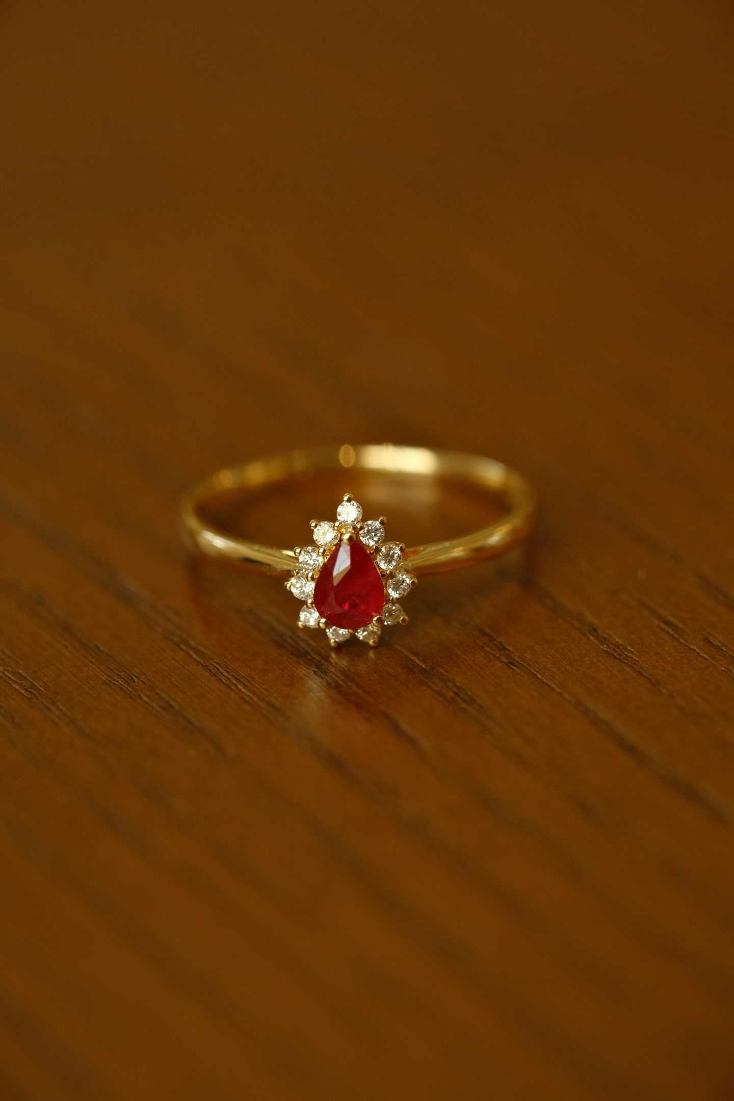 18K Gold Natural Ruby Ring: Title: 18K Gold Natural Ruby Ring Description: This ring is crafted in 18K gold, featuring a natural pear-shaped ruby with a classic Princess Diana halo design, exuding a simple and elegant style. The