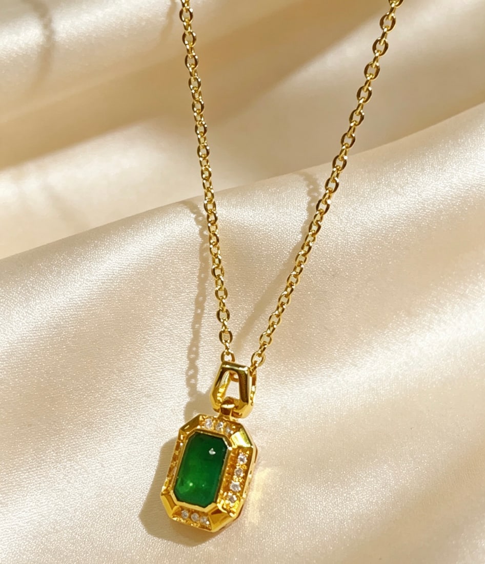 18K Gold Emerald Pendant: Title: 18K Gold Emerald Pendant Description: This pendant is meticulously set in 18K gold, showcasing the unique charm of the emerald. Surrounded by 14 diamonds, it adds a dazzling brilliance.