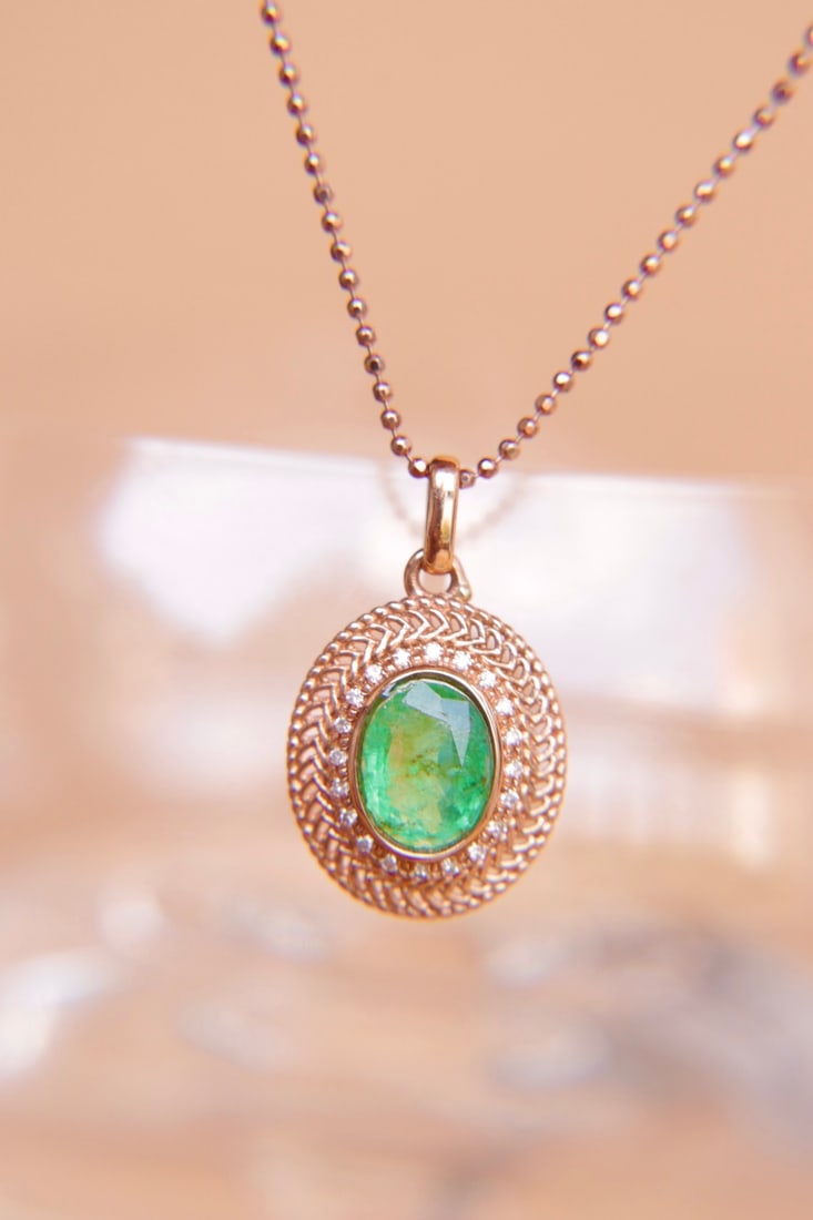 18K Gold Natural Emerald Pendant: Title: 18K Gold Natural Emerald Pendant Description: This pendant is meticulously crafted in 18K gold, set with a natural emerald that showcases a captivating color. Paired with South African