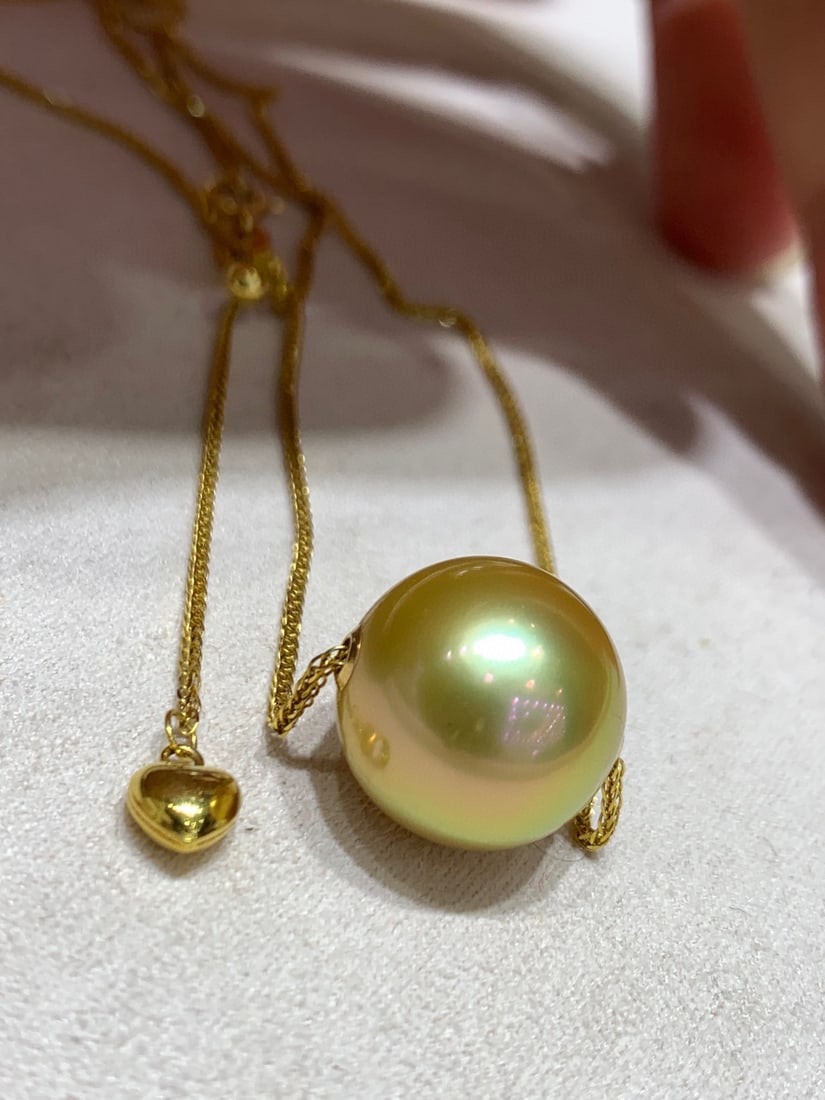 18K Gold Natural South Sea Golden Pearl Necklace: Title: 18K Gold Natural South Sea Golden Pearl Necklace Description: This necklace features an 18K gold chain paired with a South Sea golden pearl, with a diameter ranging from 12 to 13mm. The pearl e