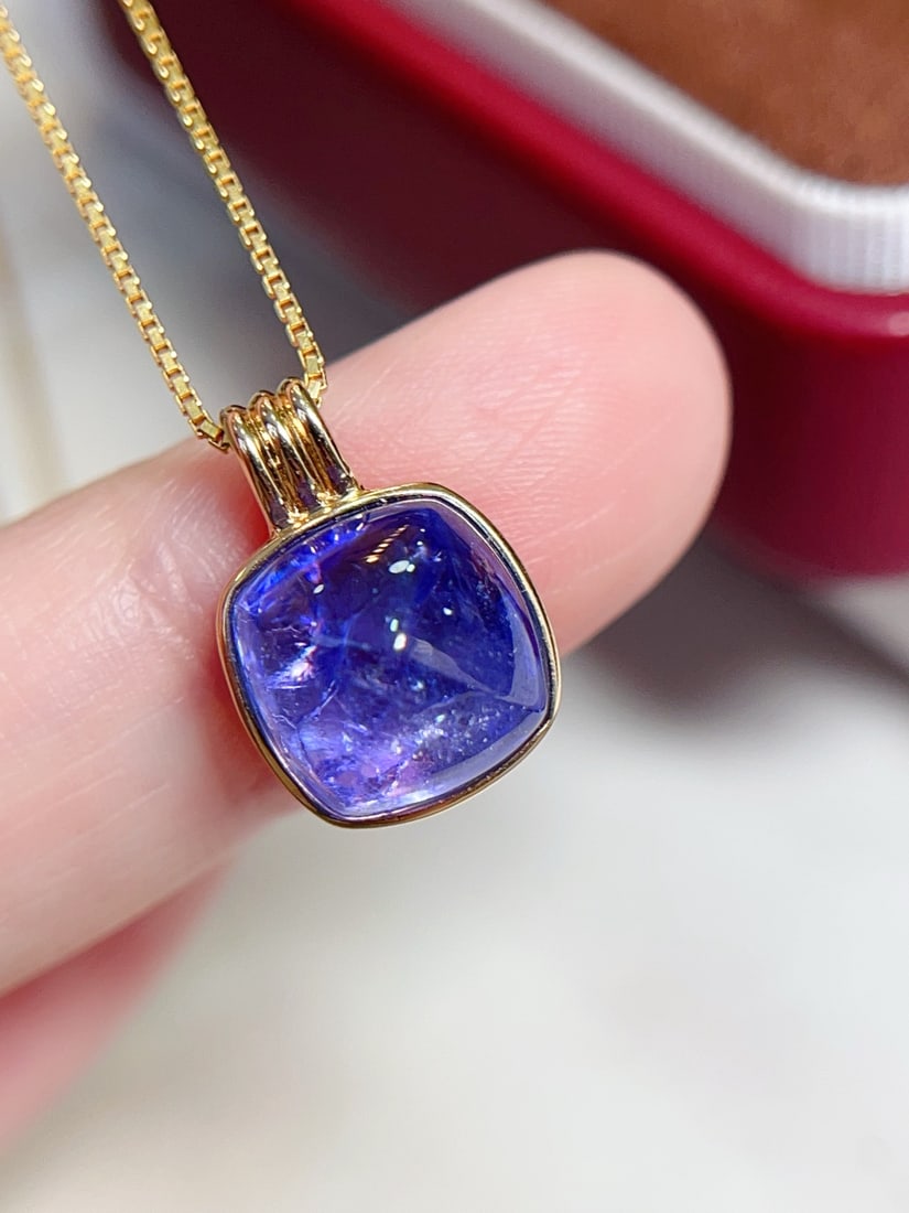 18K Gold Tanzanite Pendant: Title: 18K Gold Tanzanite Pendant Description: This pendant is crafted from 18K gold, featuring a beautifully colored tanzanite with a fluorescent glow. Its minimalist design highlights the pure