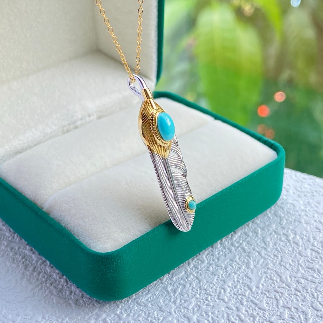 S925 Silver Natural Turquoise Pendant: Title: S925 Silver Natural Turquoise Pendant Description: This pendant features an exquisite feather design, symbolizing freedom and elegance. The unique glow of the natural turquoise seems to