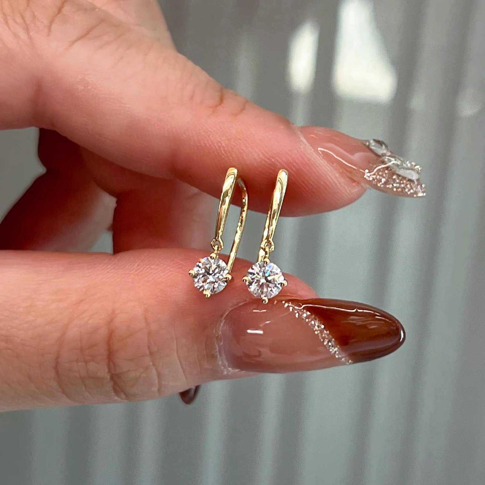 18K Gold Lab-Grown Diamond Earrings: Title: 18K Gold Lab-Grown Diamond Earrings Description: These earrings are crafted from 18K gold, showcasing exquisite craftsmanship. The lab-grown diamonds, held by four prongs, sparkle like a