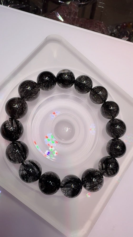 Natural Black Rutilated Quartz Bracelet: Title: Natural Black Rutilated Quartz Bracelet Description: This bracelet is made of natural black rutilated quartz, featuring transparent crystals with dense rutile needles, showcasing a unique beaut