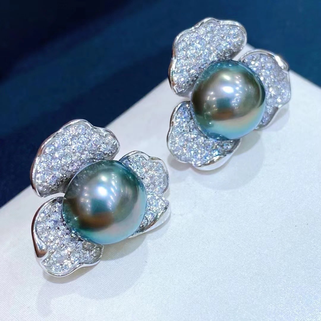 18K Gold Black Pearl Earrings: Title: 18K Gold Black Pearl Earrings Description: These earrings showcase the unique charm of black pearls with their luster and iridescent peacock green hue. The nearly flawless surface makes them an