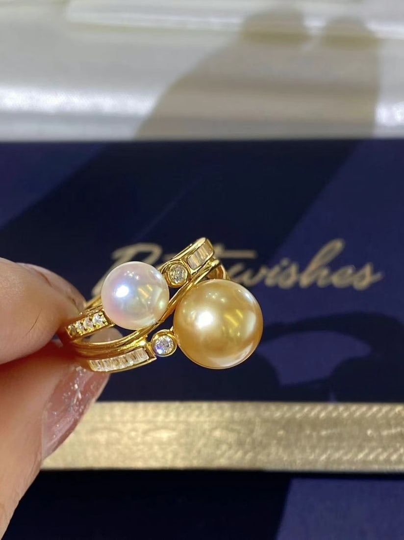 Sterling Silver South Sea Golden Pearl Ring: Title: Sterling Silver South Sea Golden Pearl Ring Description: This ring features a sterling silver base adorned with two precious sea pearls, exuding understated luxury. The combination of cool
