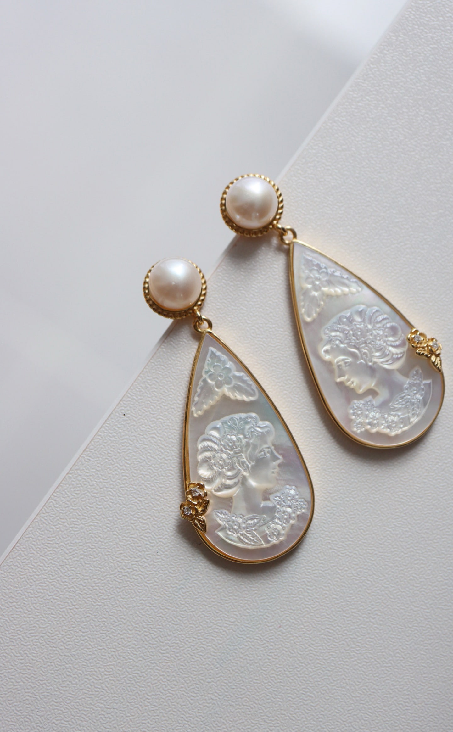 Natural White Mother-of-Pearl Earrings: Title: Natural White Mother-of-Pearl Earrings Description: These earrings feature natural white mother-of-pearl, intricately carved with a human head motif, showcasing unique artistic charm. The